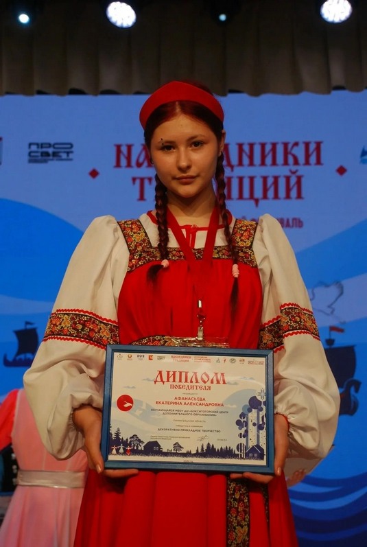 Победительница фестиваля Афанасьева Екатерина позирует с дипломом на сцене